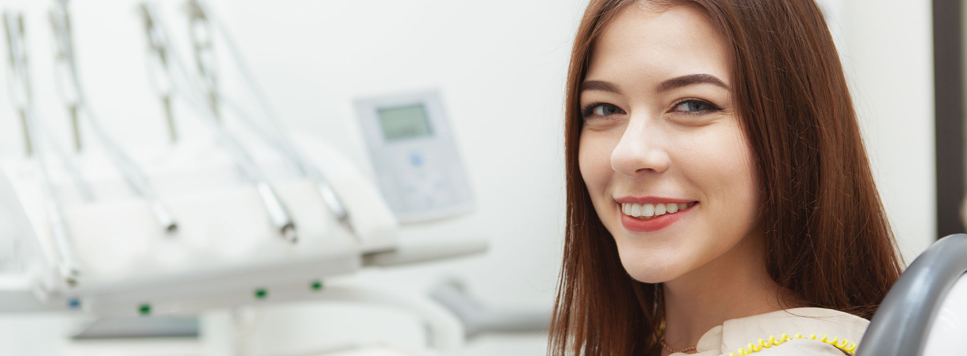 A well-lit reception area with a desk, computer monitor, and potted plant.